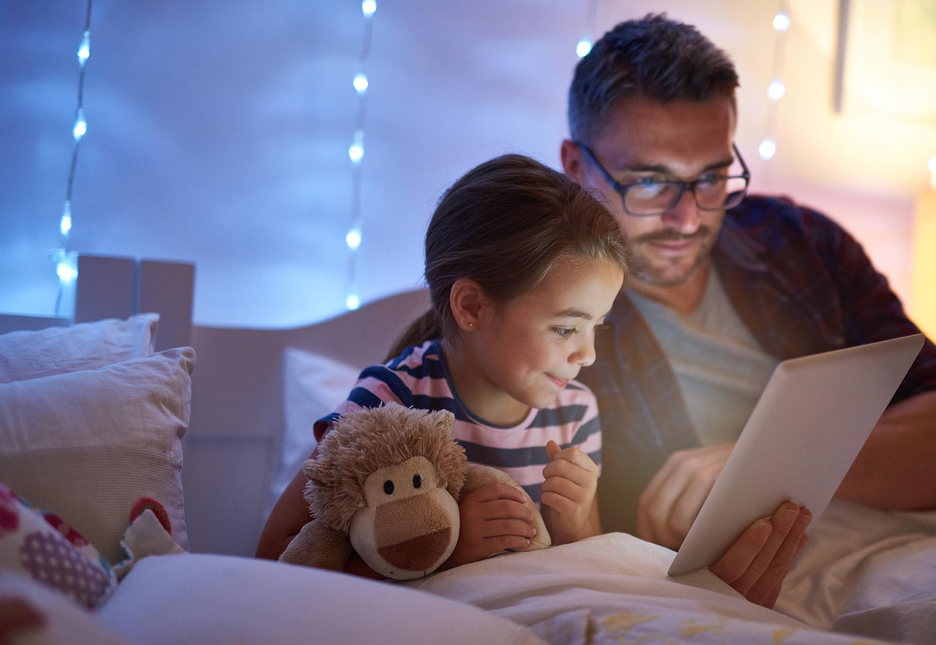 Dad and daughter watch a tablet together