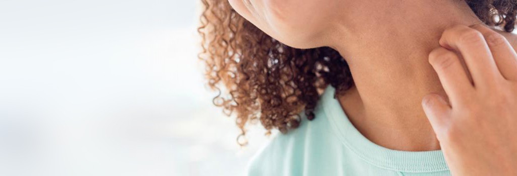image of a woman scratching a rash on her neck