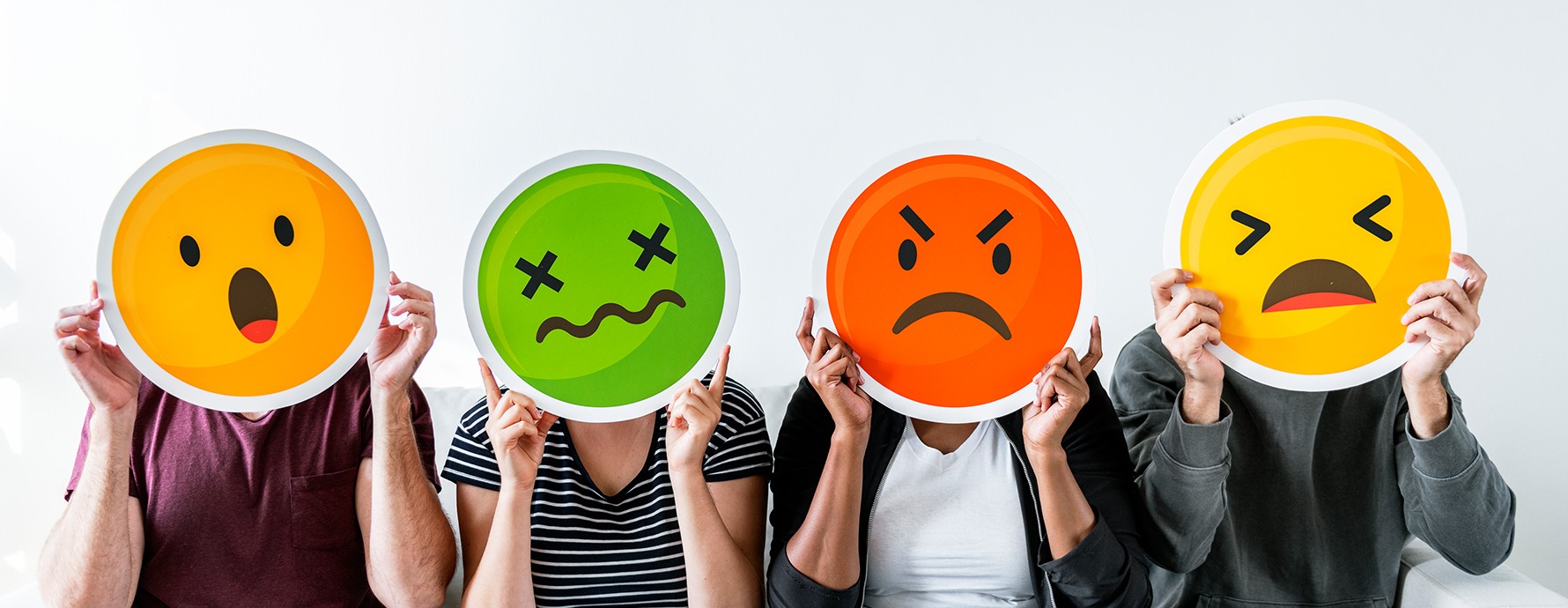 people hold up images of a shocked, nauseated, angry, and frustrated face in front of their own