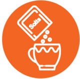 a packet of salt pouring into a mug full of hot water